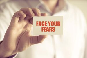  face your fears written on piece of paper held by calgary counselling services client